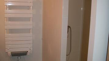 A bathroom with a checkered floor, a white radiator, and a shower area.