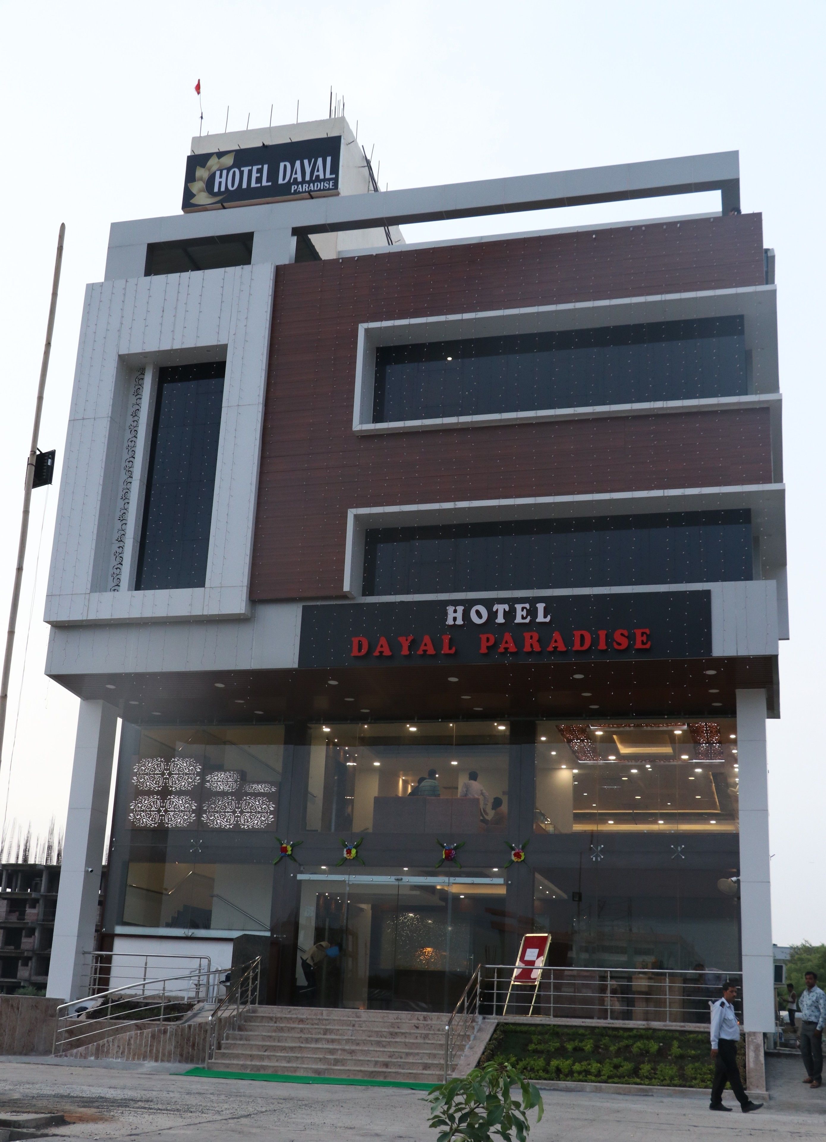 A modern hotel with a sign reading "HOTEL DAYAL PARADISE."