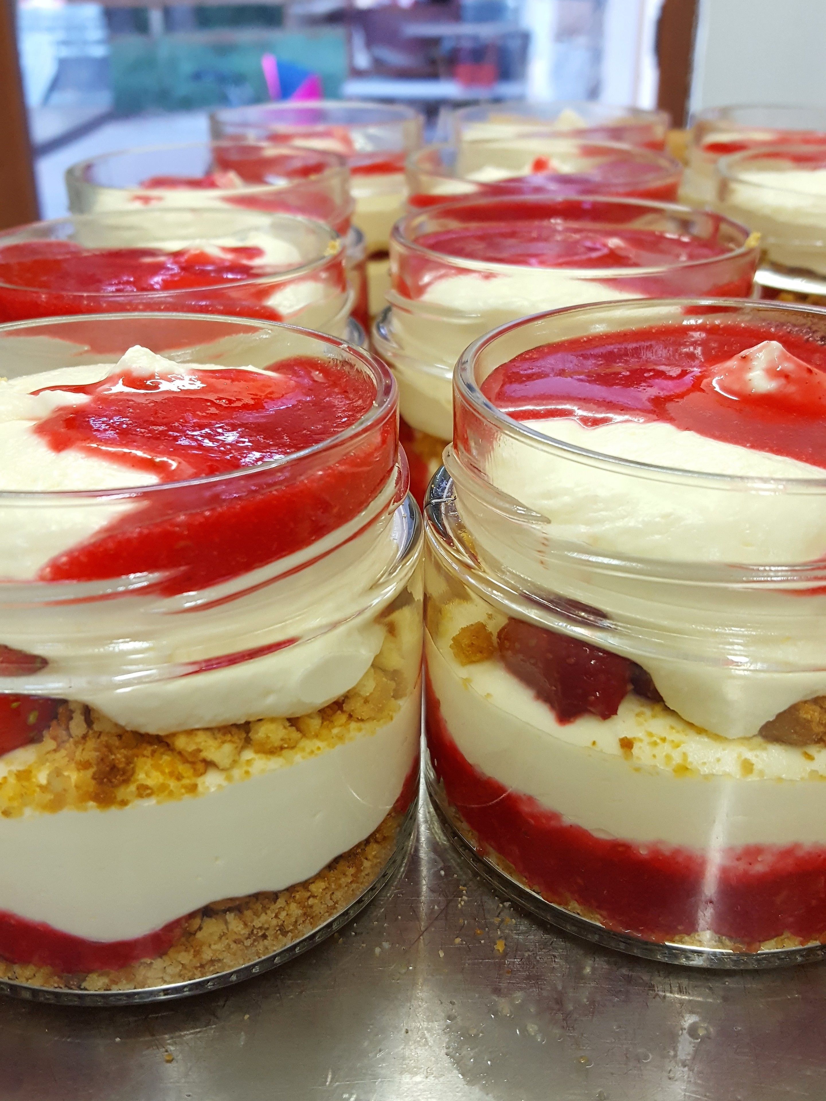 A dessert display with layered desserts in clear jars.