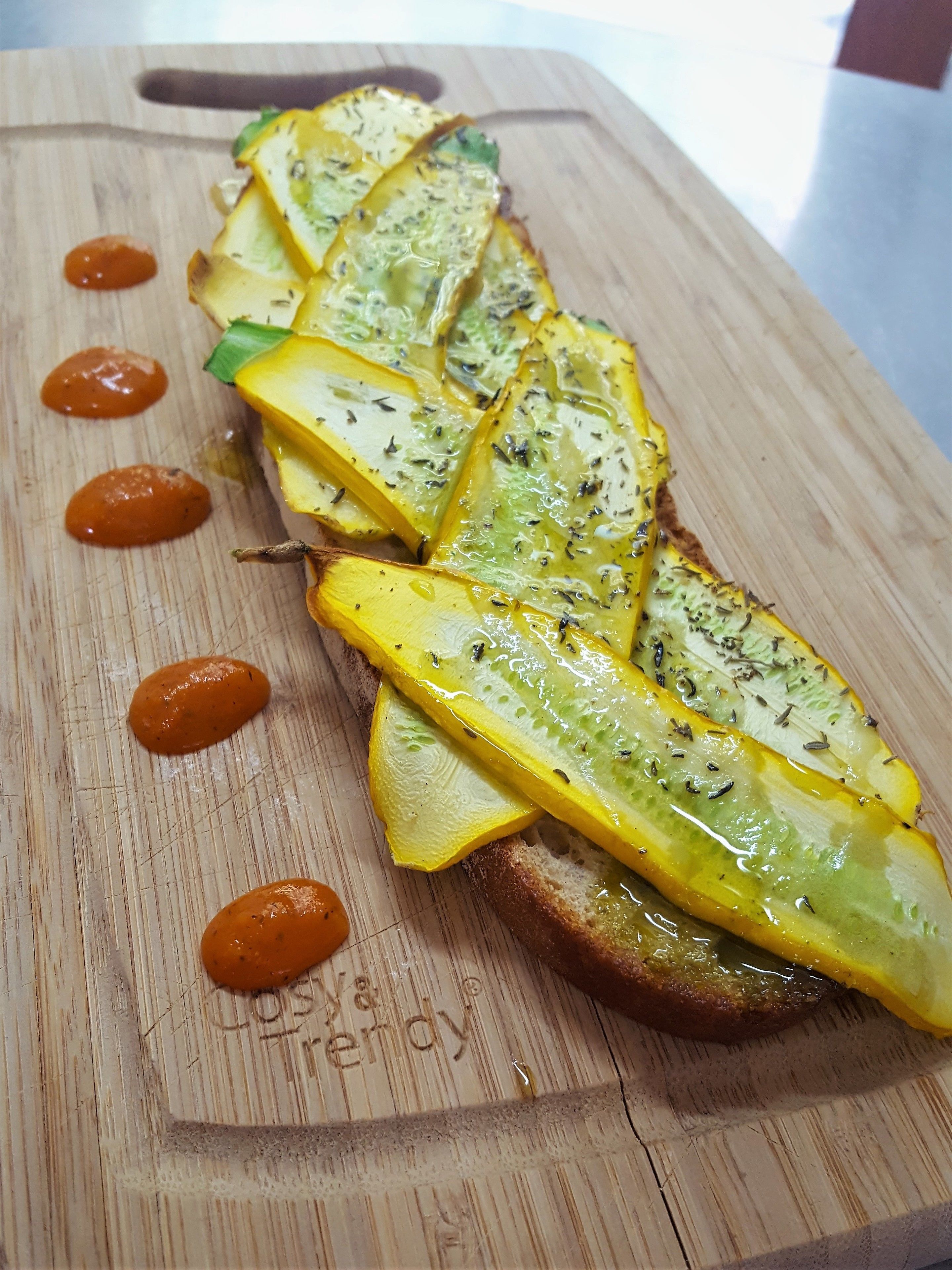 A wooden cutting board with a sliced yellow fruit, possibly a squash, arranged in a row.