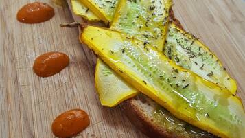 A wooden cutting board with a sliced yellow fruit, possibly a squash, arranged in a row.