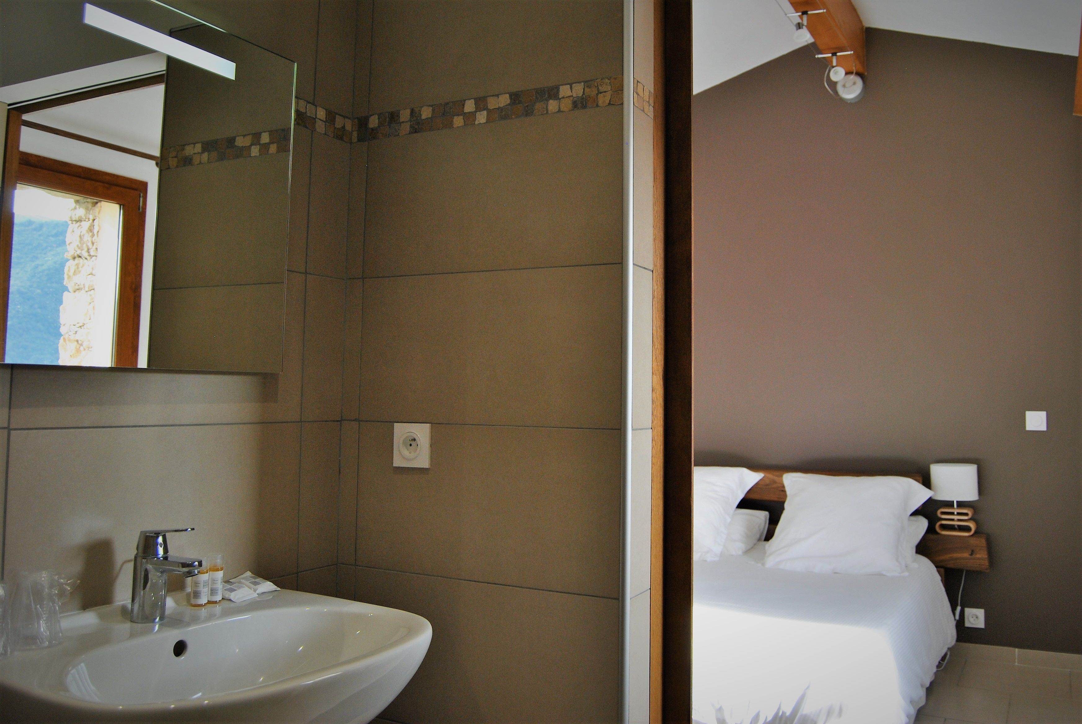 Un baño con lavamanos, espejo y ducha.
