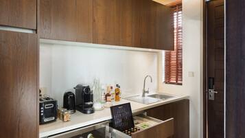 A modern kitchen with wooden cabinets, a wine cooler, and a built-in coffee maker.
