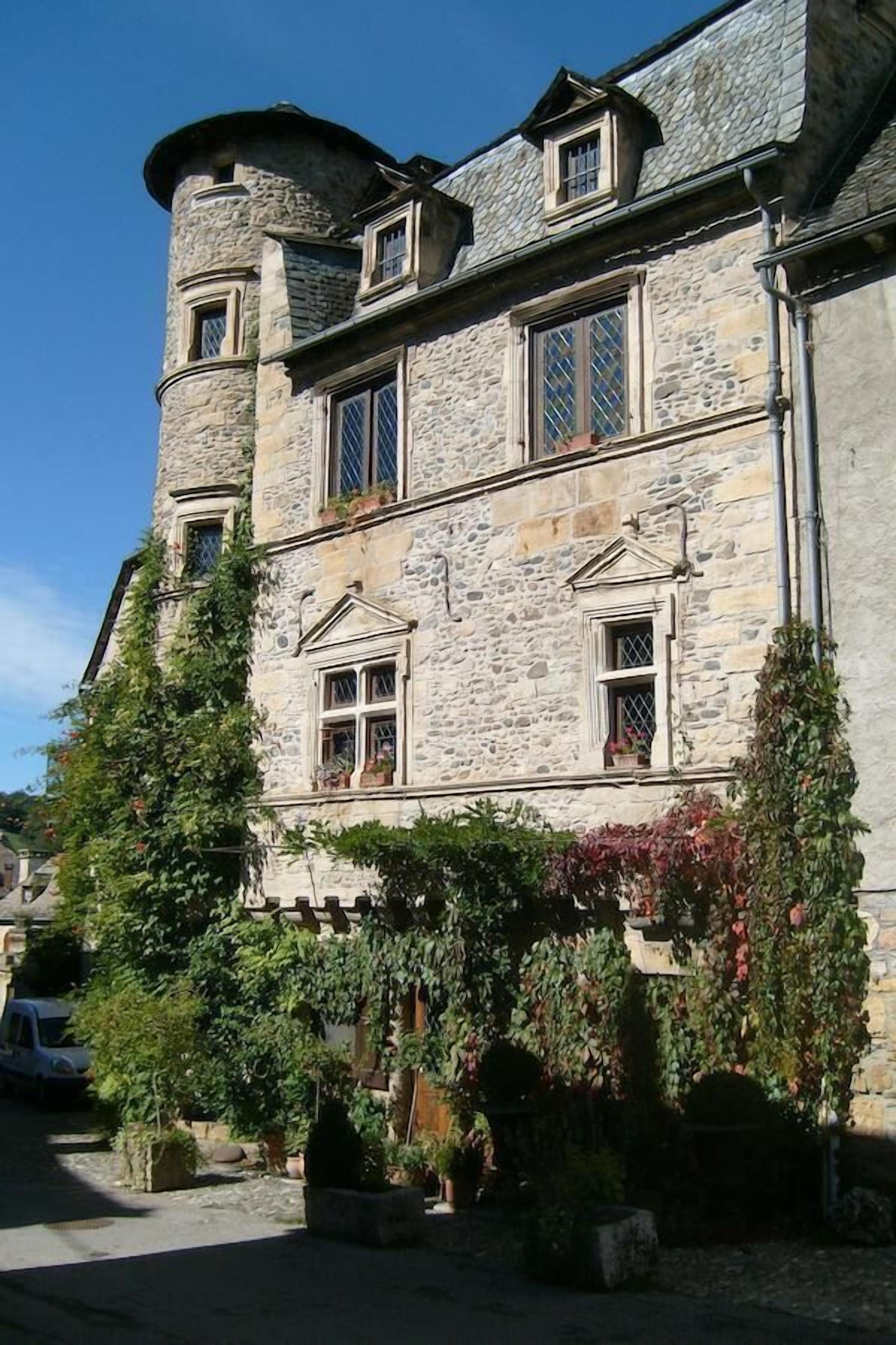 Un edificio de piedra con varias ventanas y una torre.