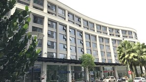 A multi-story building with a curved facade, large windows, and a covered entrance area. - Aviva Saigon Pearl (Ho Chi Minh City)