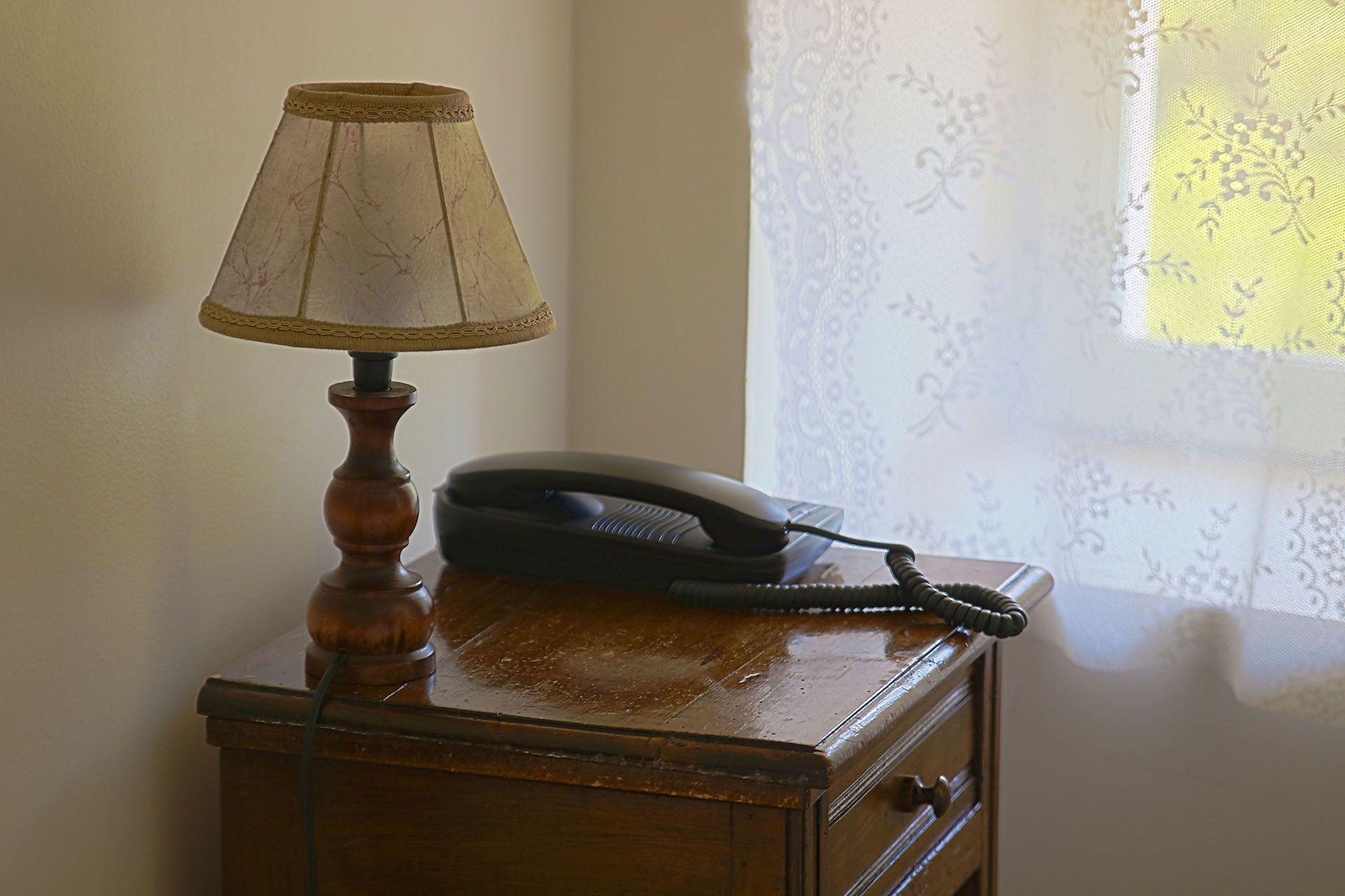 Ein Holztisch mit einer Lampe und einem Telefon.