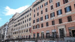 A row of multi-story buildings with uniform architectural style, featuring balconies, windows, and signage. - Domus Linda (Rome)