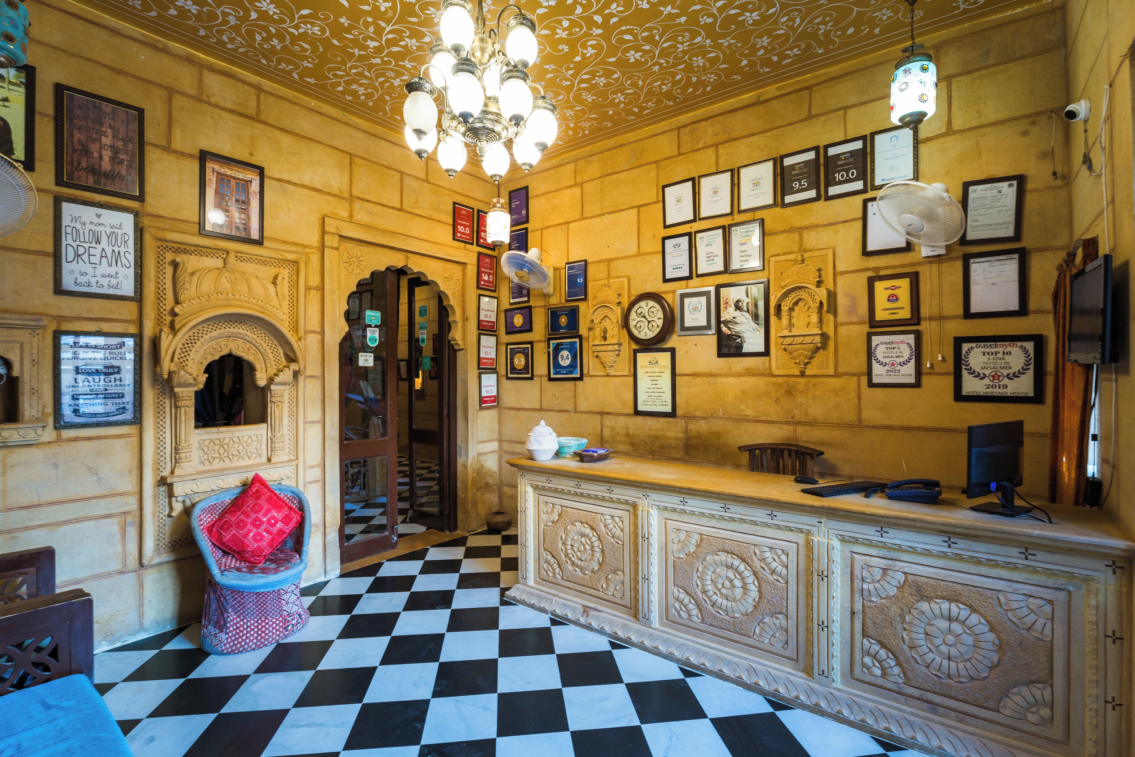 Una hall con pavimento a scacchi, una reception e diverse targhe commemorative alle pareti.