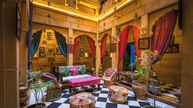 Un intérieur traditionnel avec un sol à carreaux, des meubles richement décorés et des éléments décoratifs.