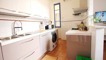 Apartamento, 3 quartos | Cozinha privada | Geladeira, micro-ondas, fogão, cooktop