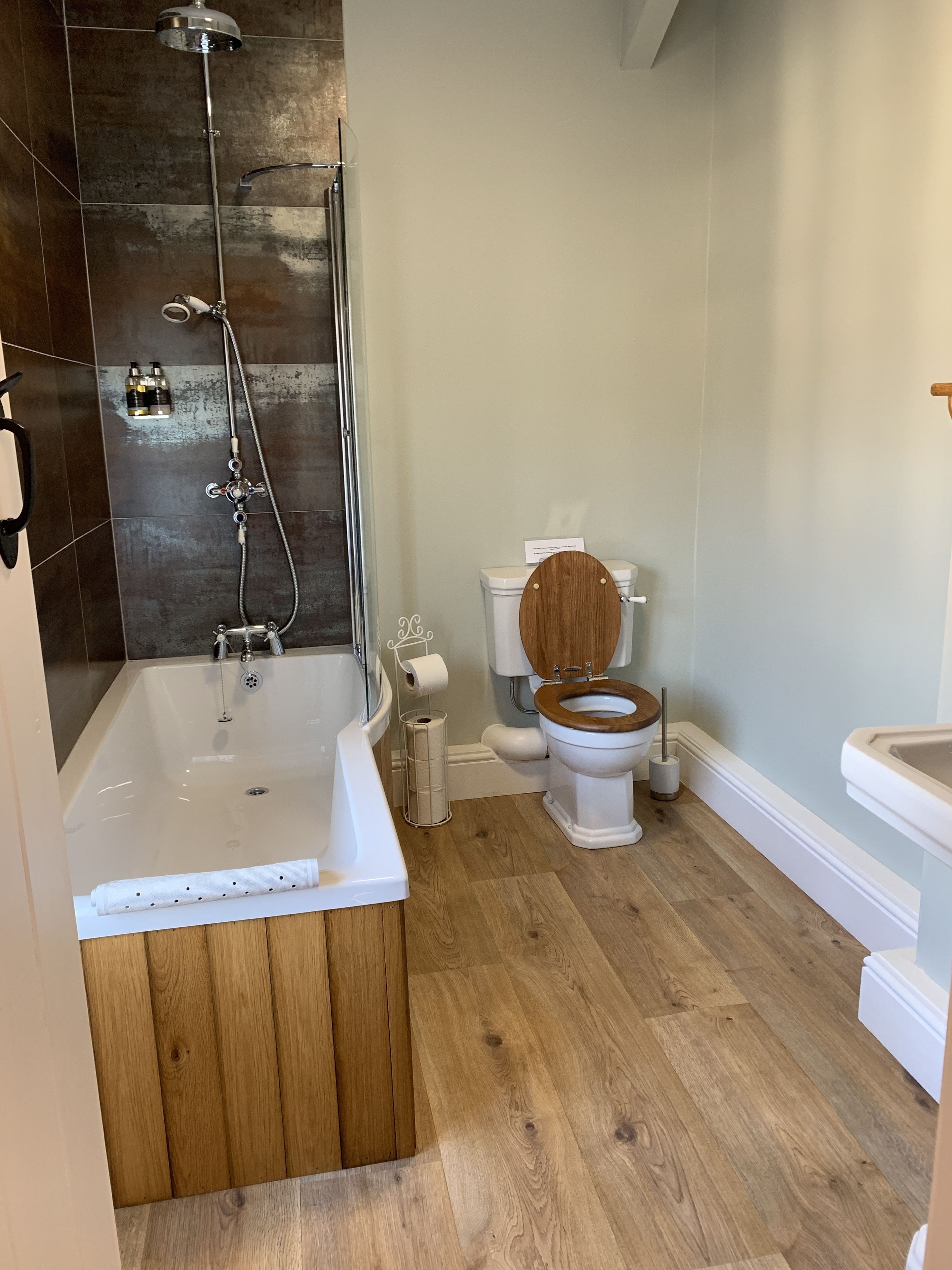 A modern bathroom with a bathtub, toilet, and sink.