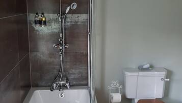 Un baño moderno con bañera, ducha, inodoro y dispensador de papel higiénico.