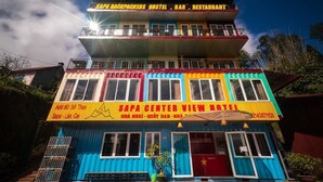 A multi-story building with colorful facades and balconies, labeled as "SAPA BACKPACKERS HOSTEL, BAR, RESTAURANT." - Sapa Center View Hotel (Sa Pa)