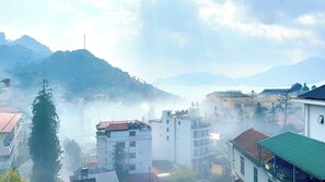 A mountainous landscape with buildings, including a prominent structure with a dome. - Sapa Center View Hotel (Sa Pa)