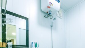 A bathroom with a white sink, a toilet, a shower, and a mirror. - Sapa Center View Hotel (Sa Pa)