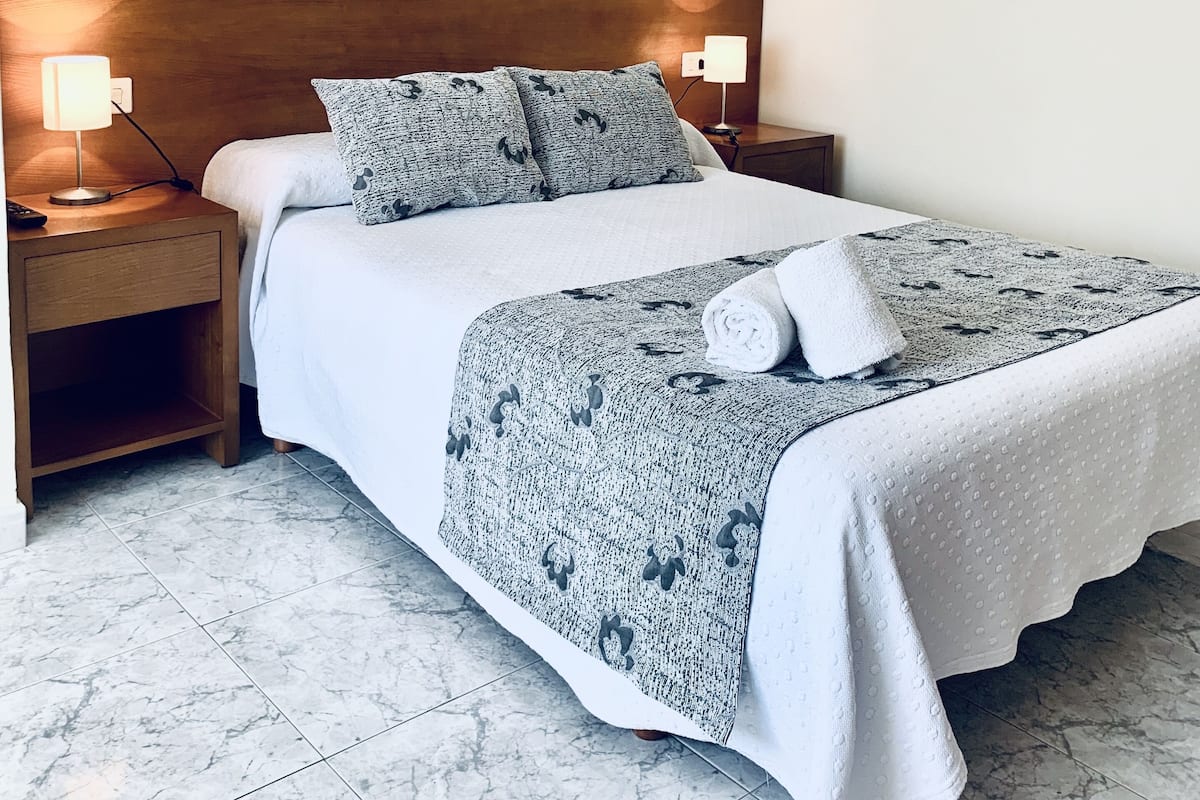 Tabla de planchar con plancha y ropa de cama