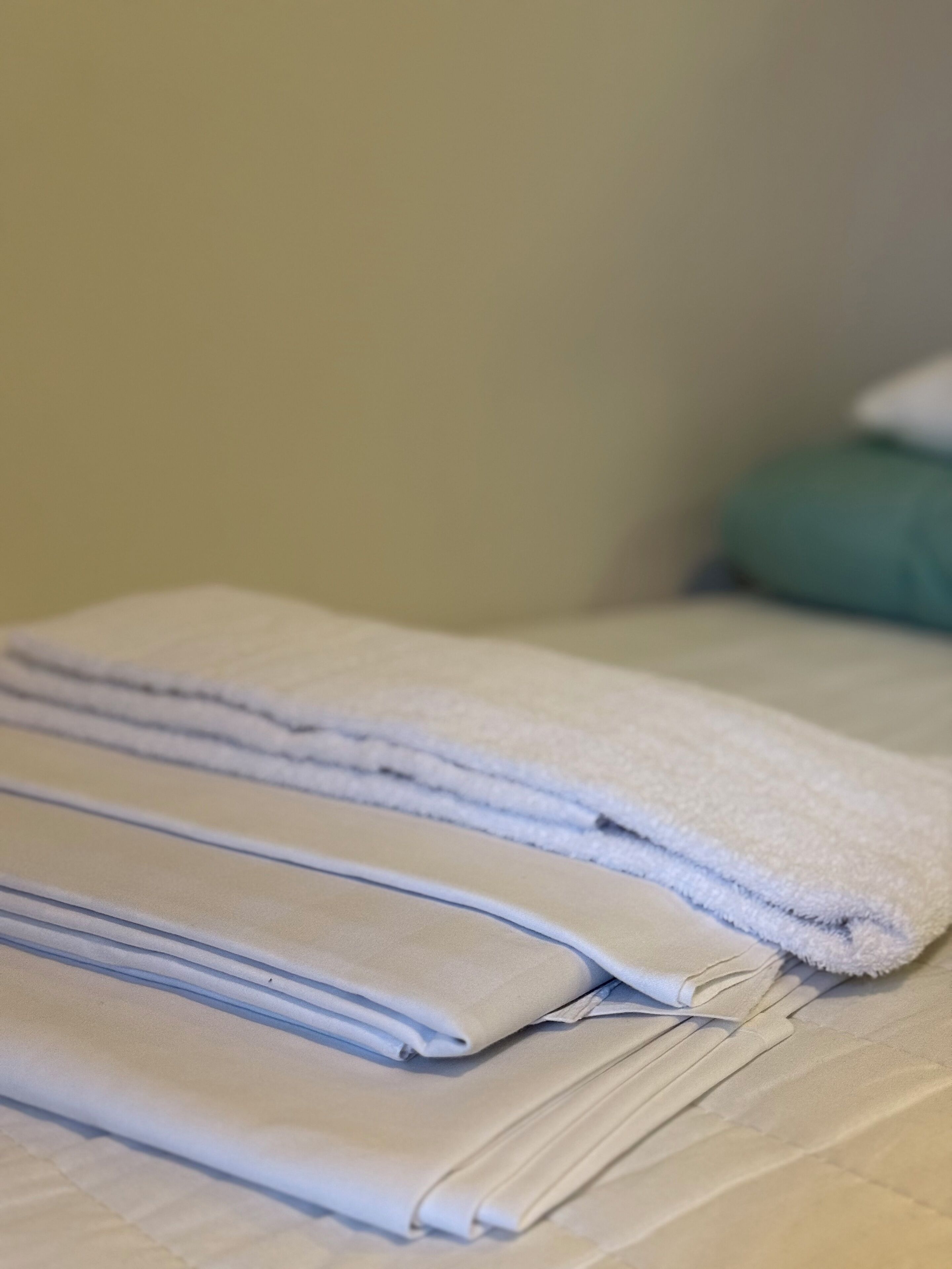 Un juego de toallas dobladas ordenadamente sobre una cama.