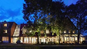 A large, multi-story building with a prominent central entrance and a sloped roof. - AKZENT Hotel Haus Surendorff (Bramsche)