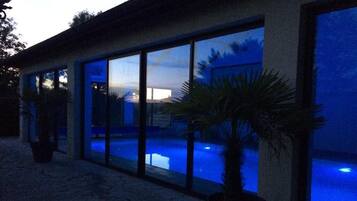 Un edificio moderno con grandes ventanales de vidrio que dan a una piscina.