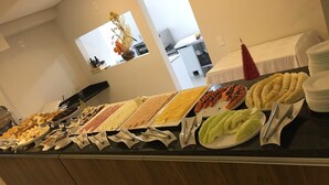 A buffet with various food items and utensils. - Ingleses Apart Hotel (Florianópolis)