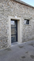 Un edificio de piedra con una puerta negra y una ventana pequeña.