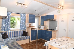 Una cocina compacta con zona de comedor, un banco empotrado y una pequeña mesa.