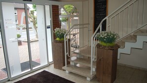 A staircase with wooden steps and white railings, leading to an upper floor.