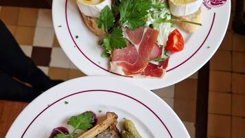 Two plates of food with various ingredients and garnishes.