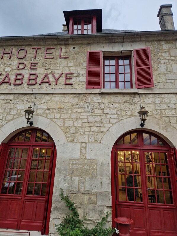A stone building with a sign reading 'HOTEL DE ABBAYE.'
