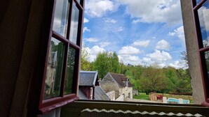 A view through a window with a clear sky and a landscape with buildings and trees. - Hotel De L'Abbaye (Longpont)