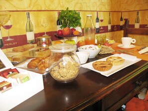 Un buffet de petit-déjeuner proposant une variété d’aliments, notamment des viennoiseries, des fruits et des boissons.
