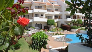 A hotel with a pool, multiple balconies, and lush greenery. - Apartamentos Hg Cristian Sur (Arona)