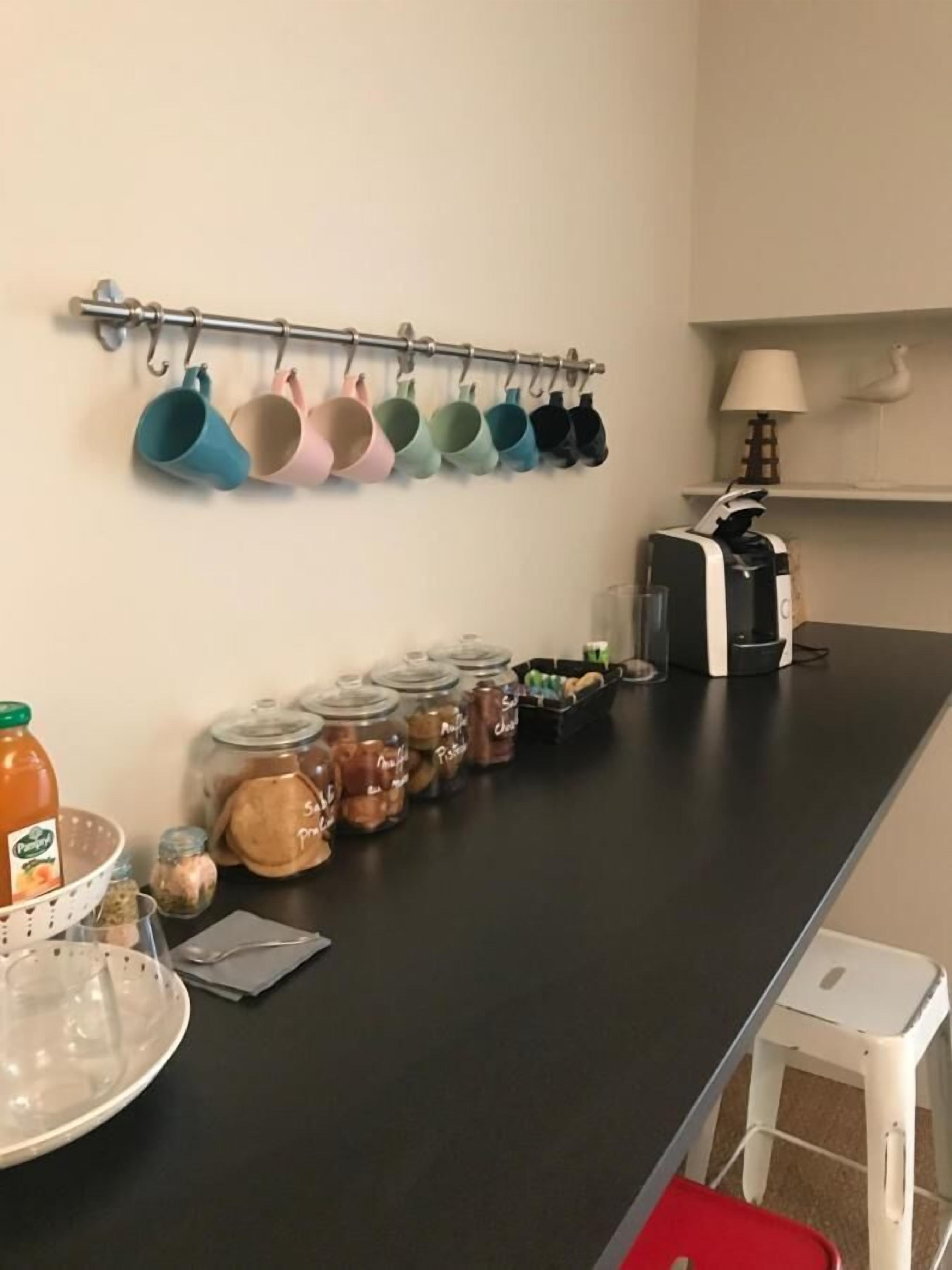 A kitchen counter with various utensils, jars of spices, and a coffee maker.