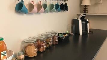 A kitchen counter with various utensils, jars of spices, and a coffee maker.