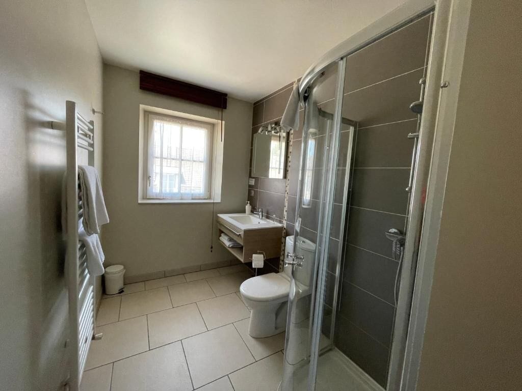A bathroom with a toilet, sink, and shower.