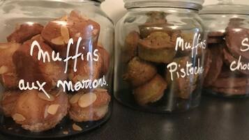 Tres frascos de vidrio etiquetados con distintos tipos de muffins: 'Muffins aux Marrons', 'Muffins Pistache' y 'Muffins Choco'.