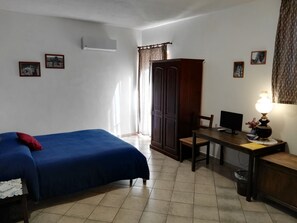 A bedroom with a bed, a desk, a chair, a wardrobe, and a lamp. - Cloris Guest House (Noto)