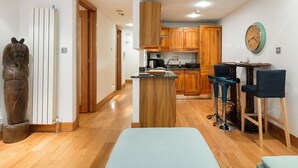 Une cuisine moderne avec des meubles en bois, un îlot central et des tabourets de bar.