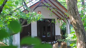 A traditional building with a porch and wooden furniture.