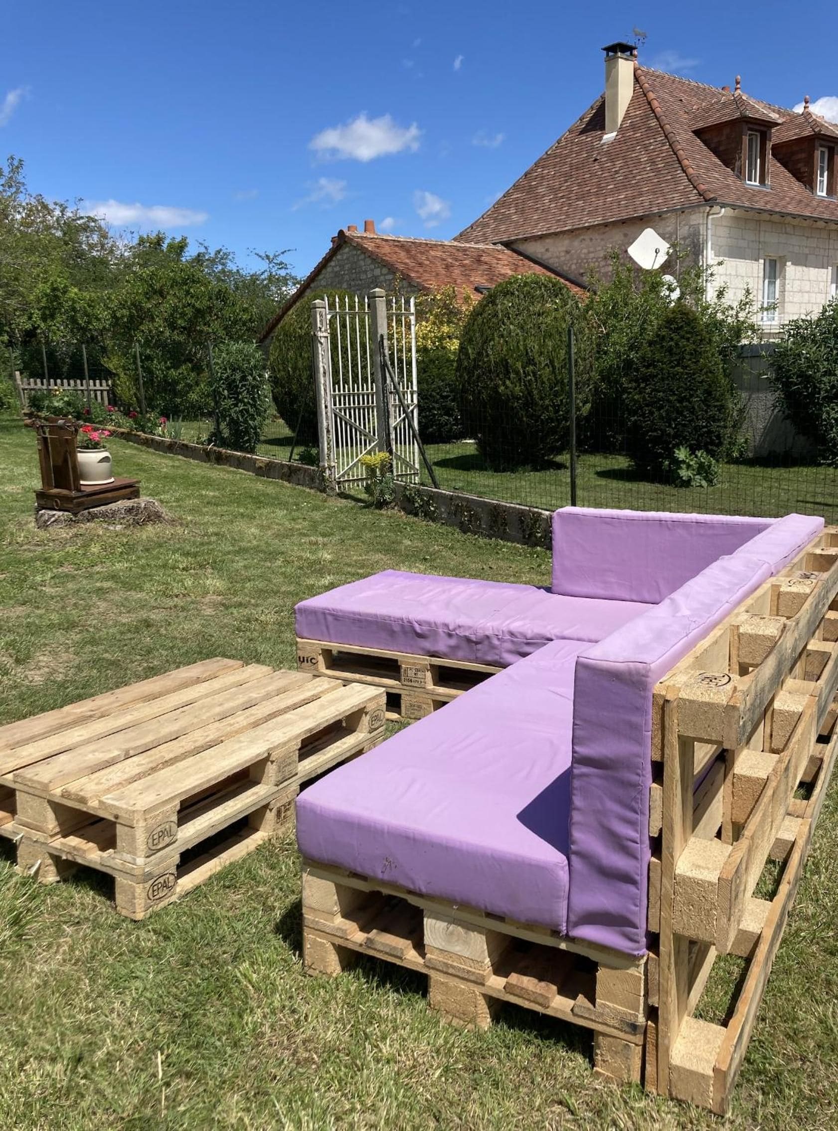 Um deck de madeira com duas cadeiras de descanso e uma mesa pequena.