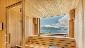 A wooden sauna with a large window offering a view of the sea and mountains. - Monte Palm Beach (Durasevici)