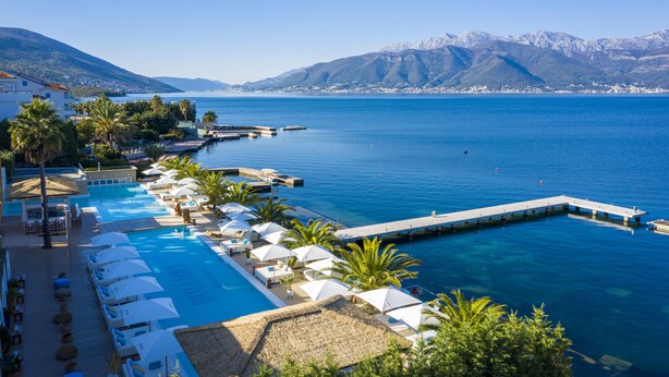 A resort with a swimming pool, sun loungers, umbrellas, and a pier extending into the water. - Monte Palm Beach (Durasevici)