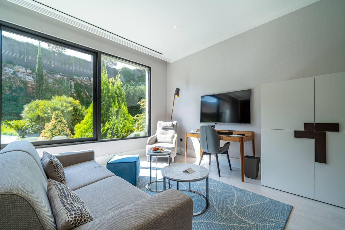 A modern living room with a sofa, a coffee table, a TV, and a desk.