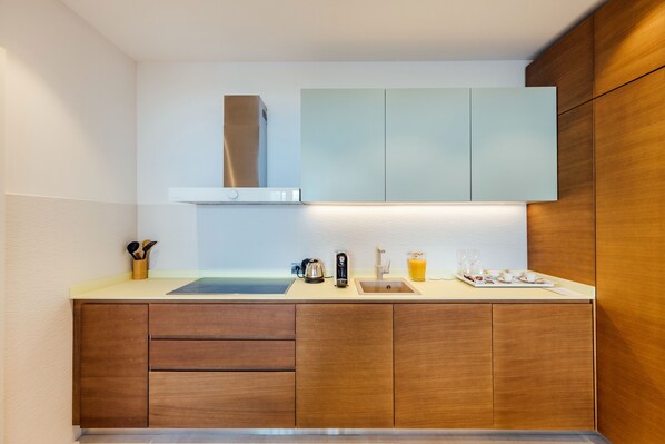Una cocina moderna con estufa integrada, un fregadero y armarios de madera.