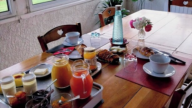 Una mesa de desayuno con una bandeja de comida, bebidas y aderezos.