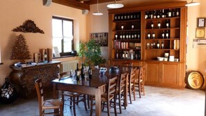 Un coin repas avec une table et des chaises en bois, un meuble à vin et un sapin de Noël.