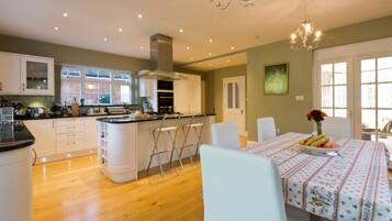 A modern kitchen with white cabinets, a central island, and a dining area with a table set for two.