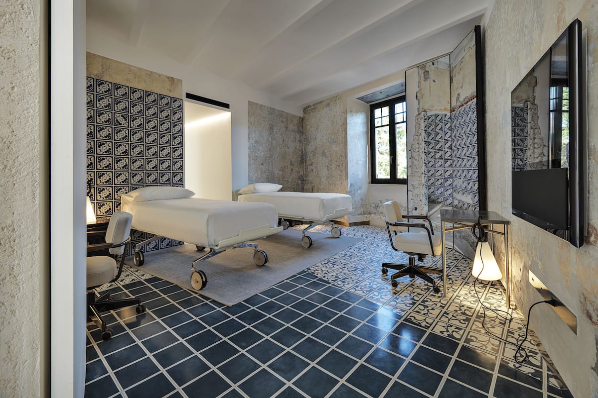 A room with two beds, a desk, and a chair.