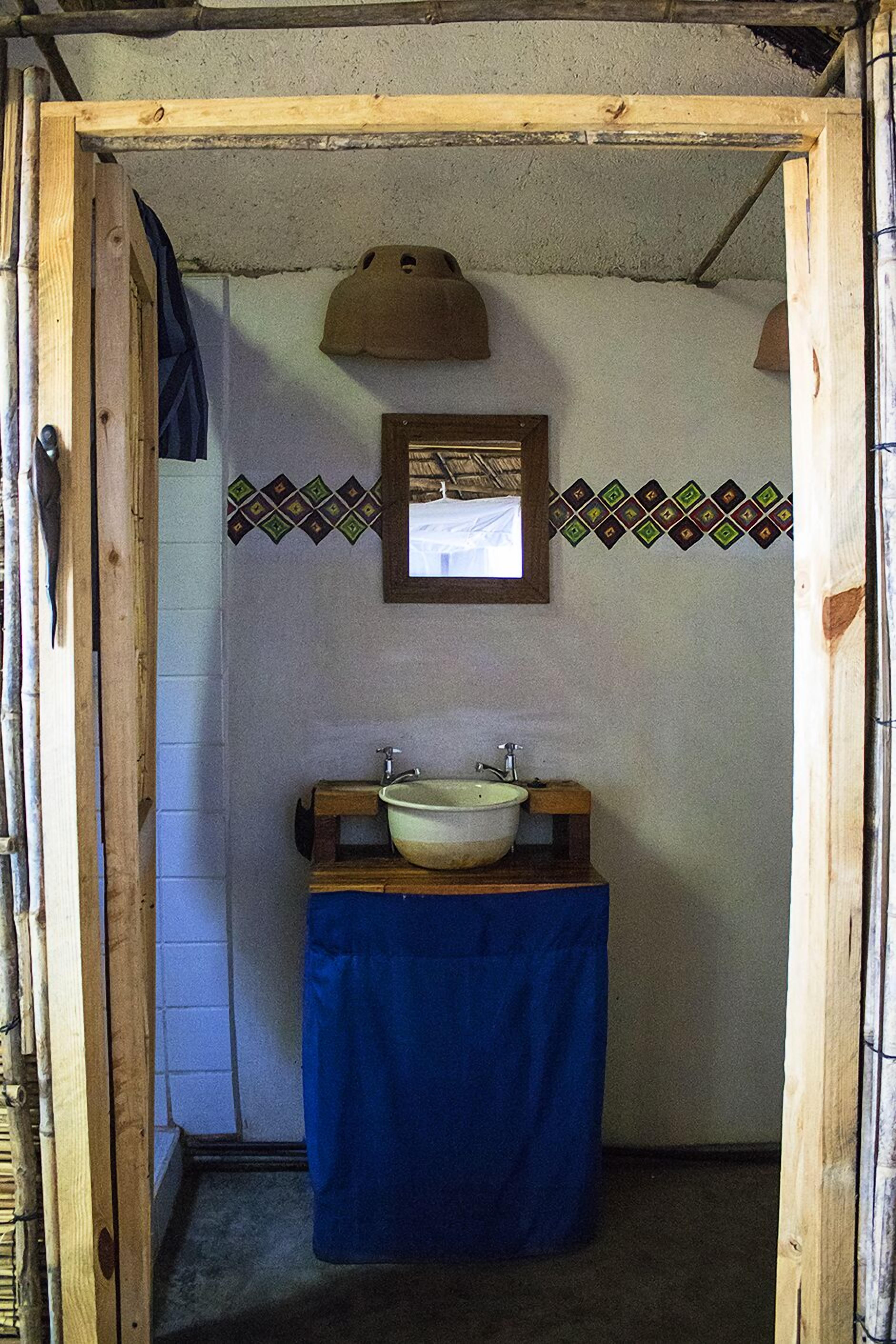 Une petite salle de bain avec un cadre en bois, un lavabo et un miroir.