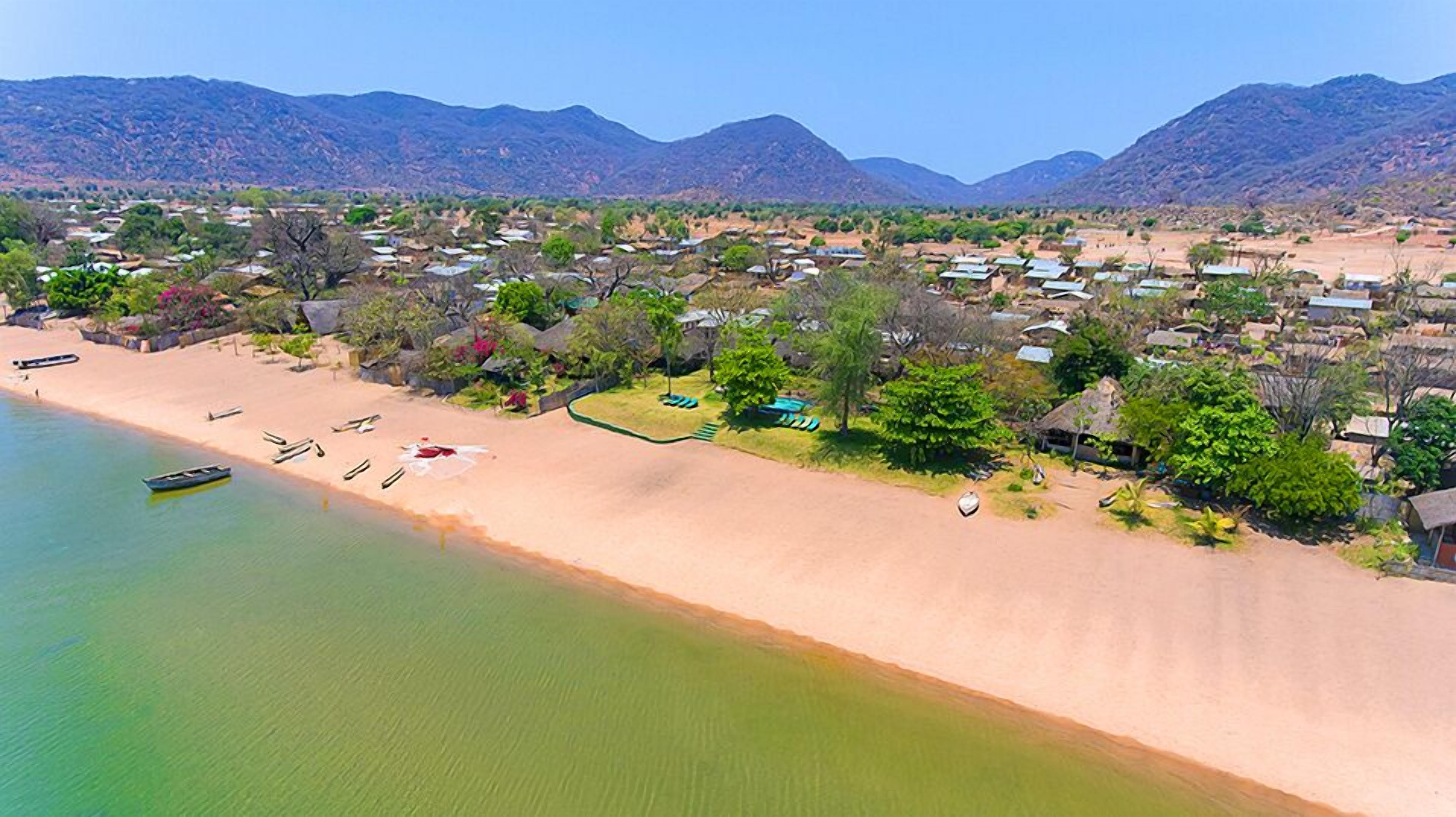 Une station balnéaire avec accès à la plage, une piscine et une vue sur les collines environnantes.